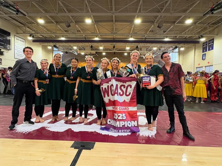 winter guard with the championships banner and coaches